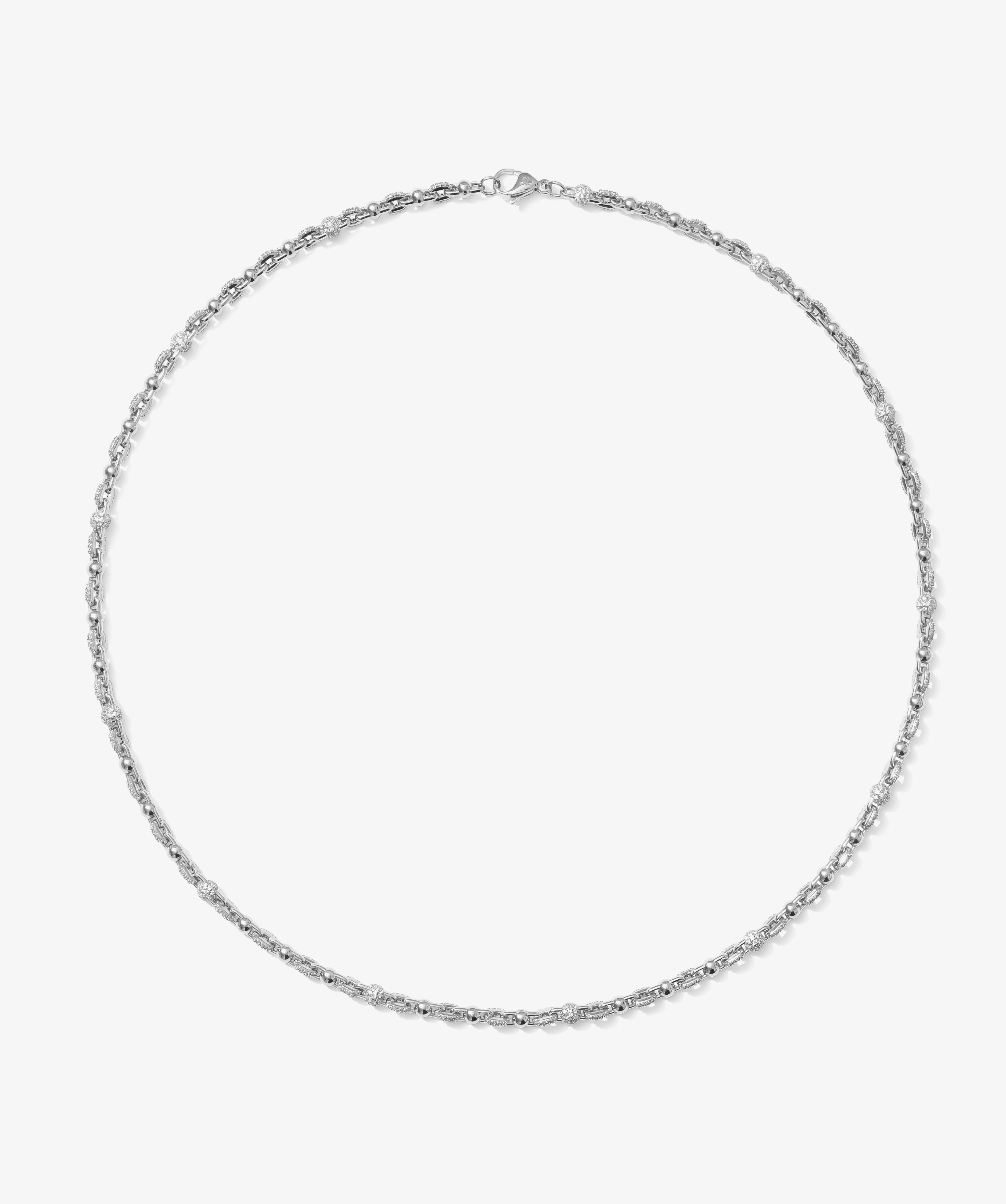 ICED London silver necklace with small stones in a delicate chain, minimalist jewelry on a white backdrop.
