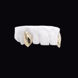 ICED London dental model: white teeth with gold crowns on molars, isolated on black background.