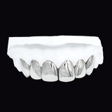 ICED London: close-up of an upper row of metallic dental crowns on a plaster dental model.