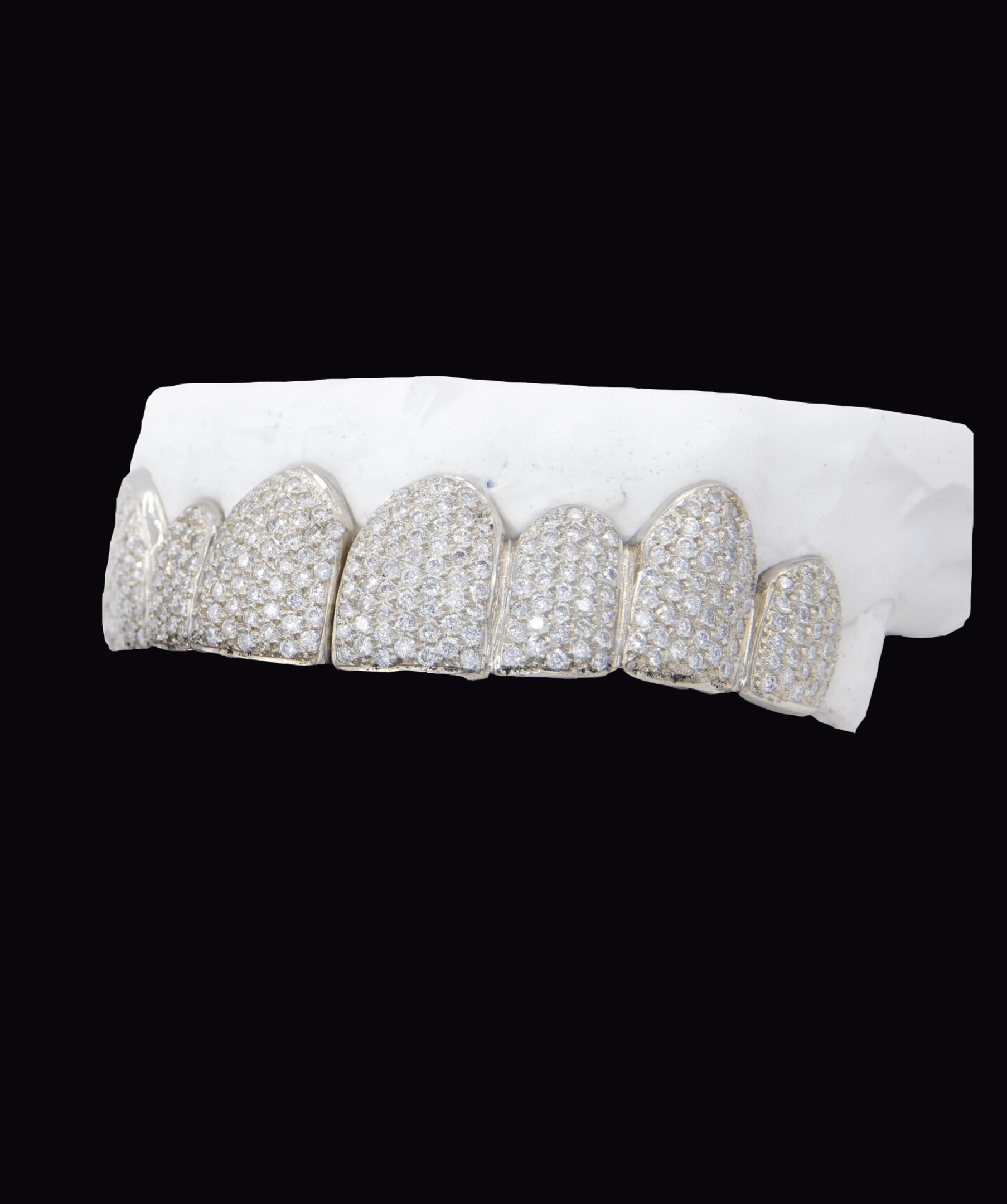 ICED London diamond-encrusted dental grill set on a white dental mold, close-up shot.