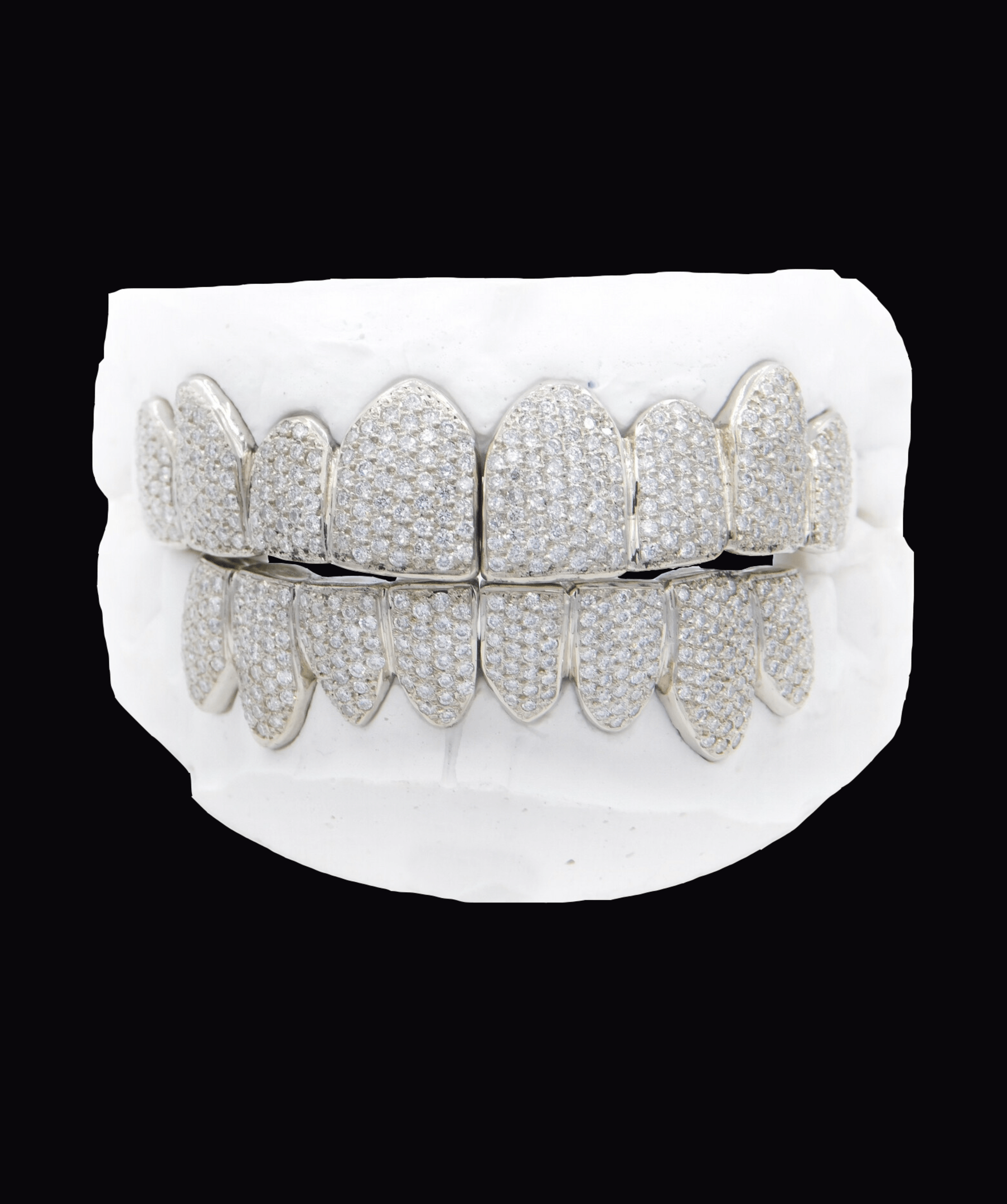 ICED London diamond-pavé grill set on a white dental mold, front view of upper and lower grills for teeth.